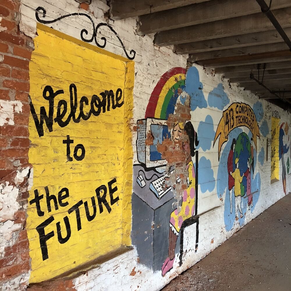 A Welcome to the Future mural left on the brick by a previous occupant