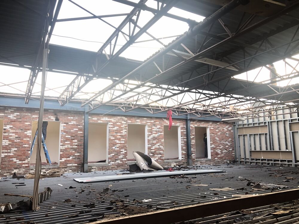 The roof opened up during construction, showing the steel truss and sky