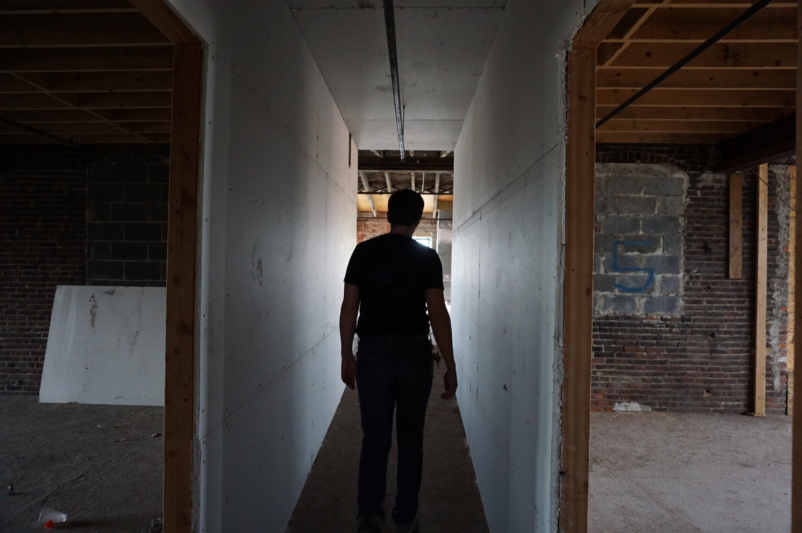 Walking down a newly framed corridor on the fifth floor at Billy Penn Studios, between gutted rooms of exposed brick and old floor joists