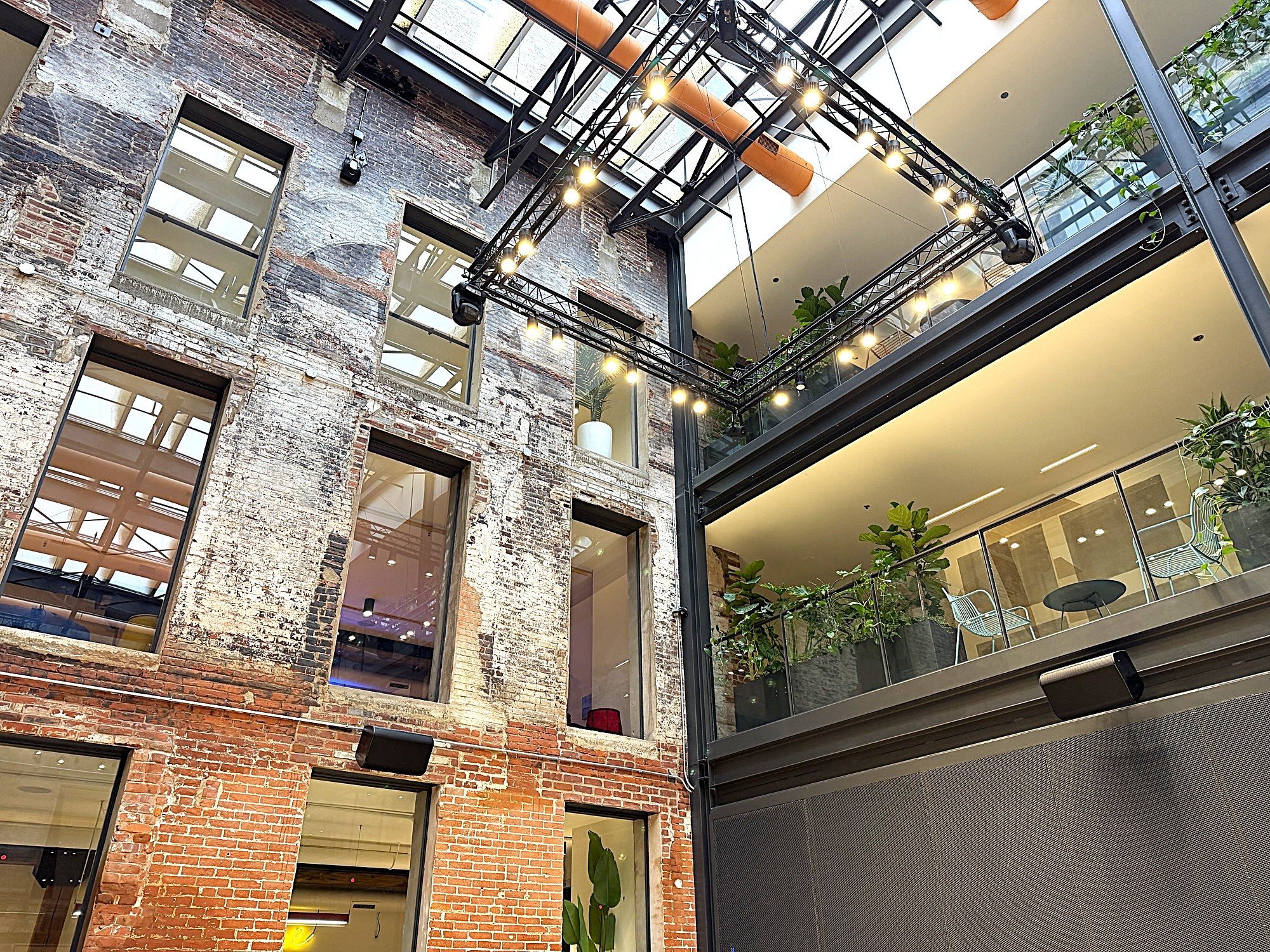 Historic exterior walls at Billy Penn Studios, now facing inward across the atrium, with new windows cut into them