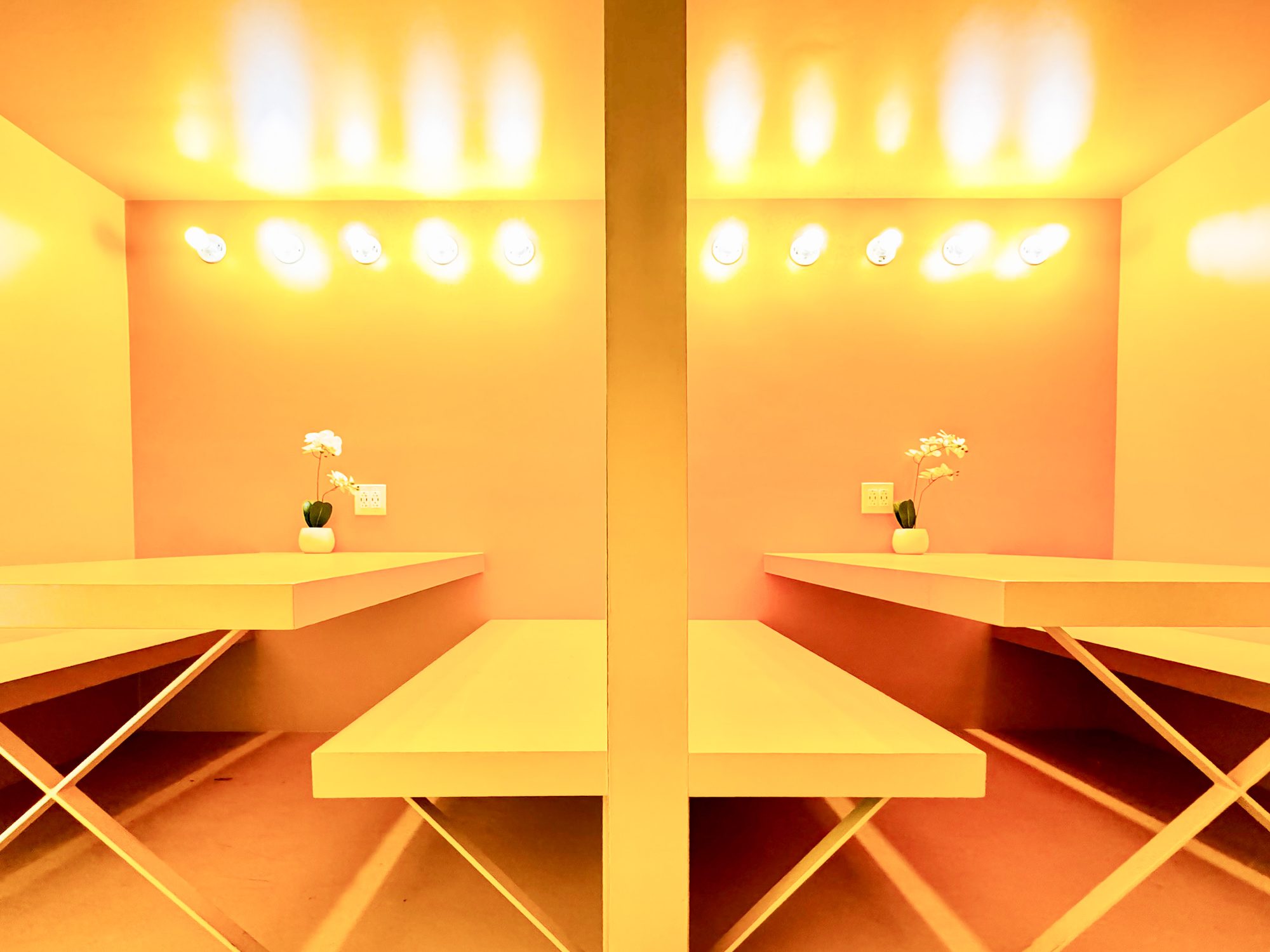 The shared work booths at Billy Penn Studios coworking, warm lit with long tables and bench seating