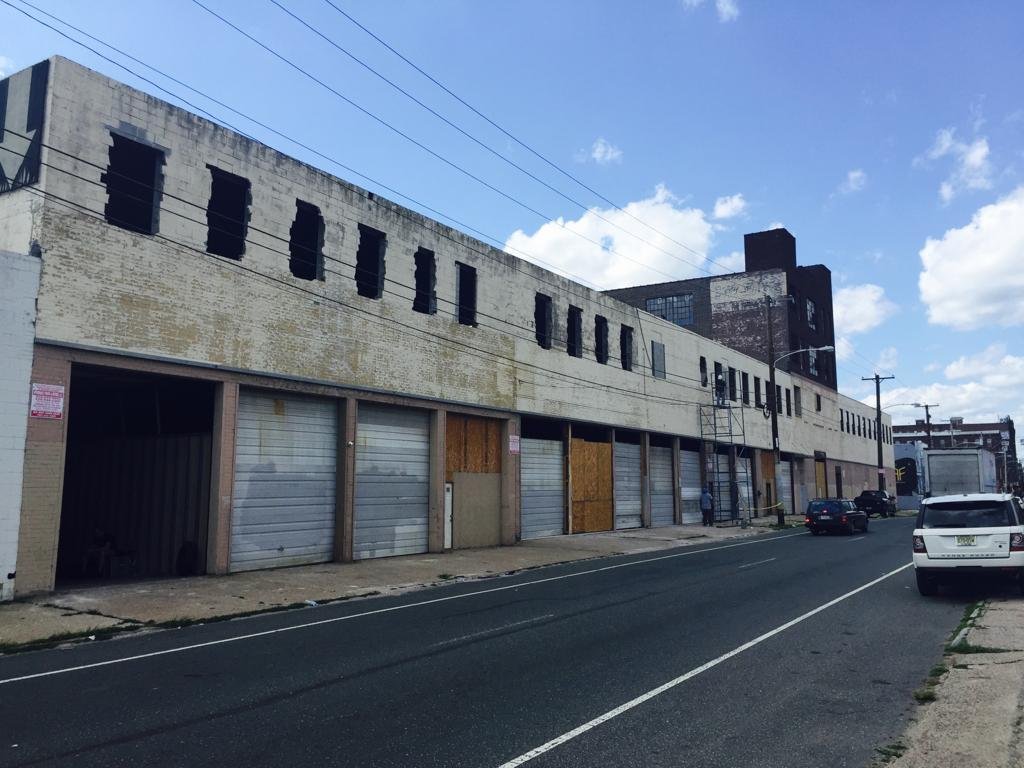 1516 N 5th Street before restoration — the boarded factory frontage running down the block in Olde Kensington, Philadelphia