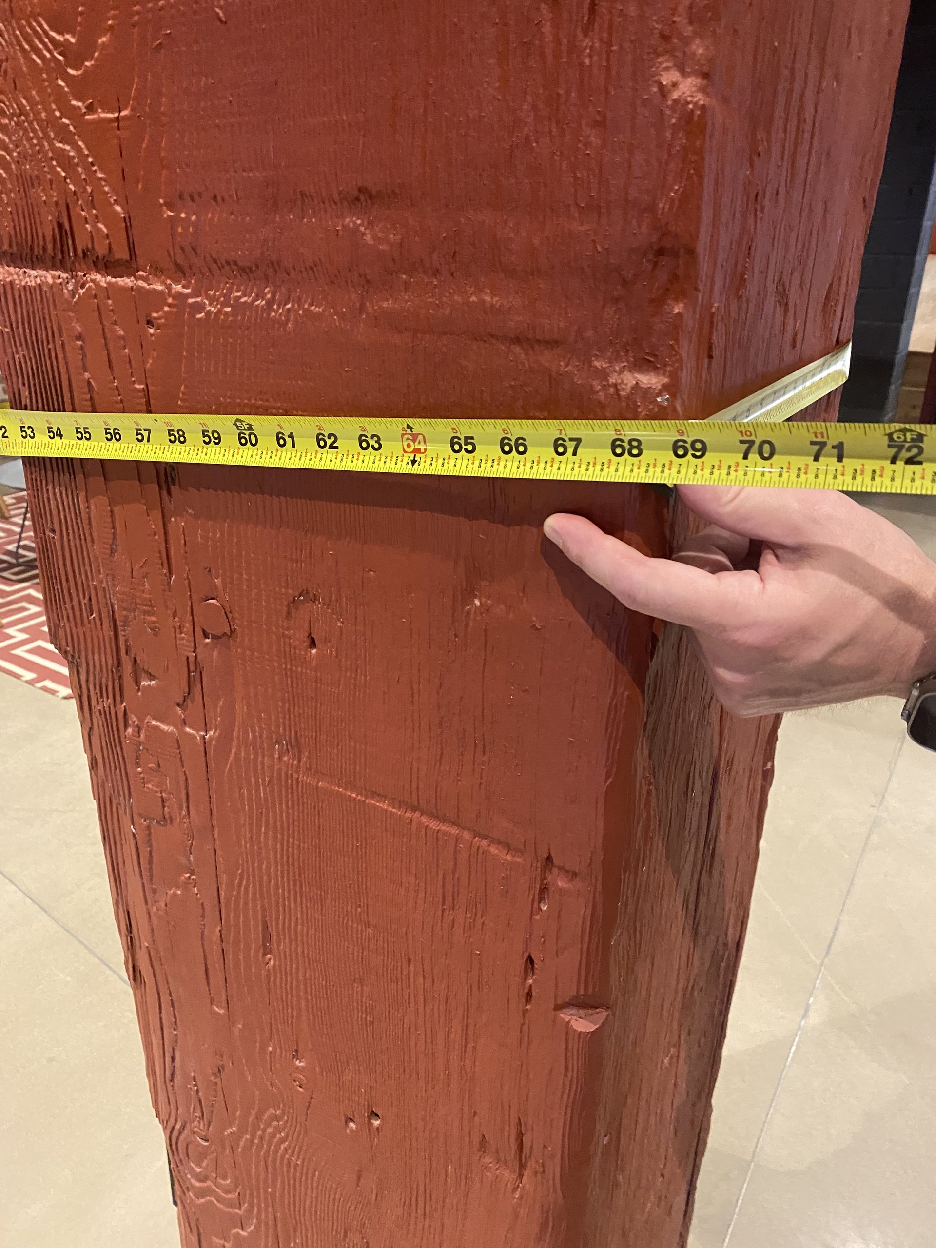 A tape measure held across one of the original Southern Yellow Pine beams at Billy Penn Studios, reading 69 inches