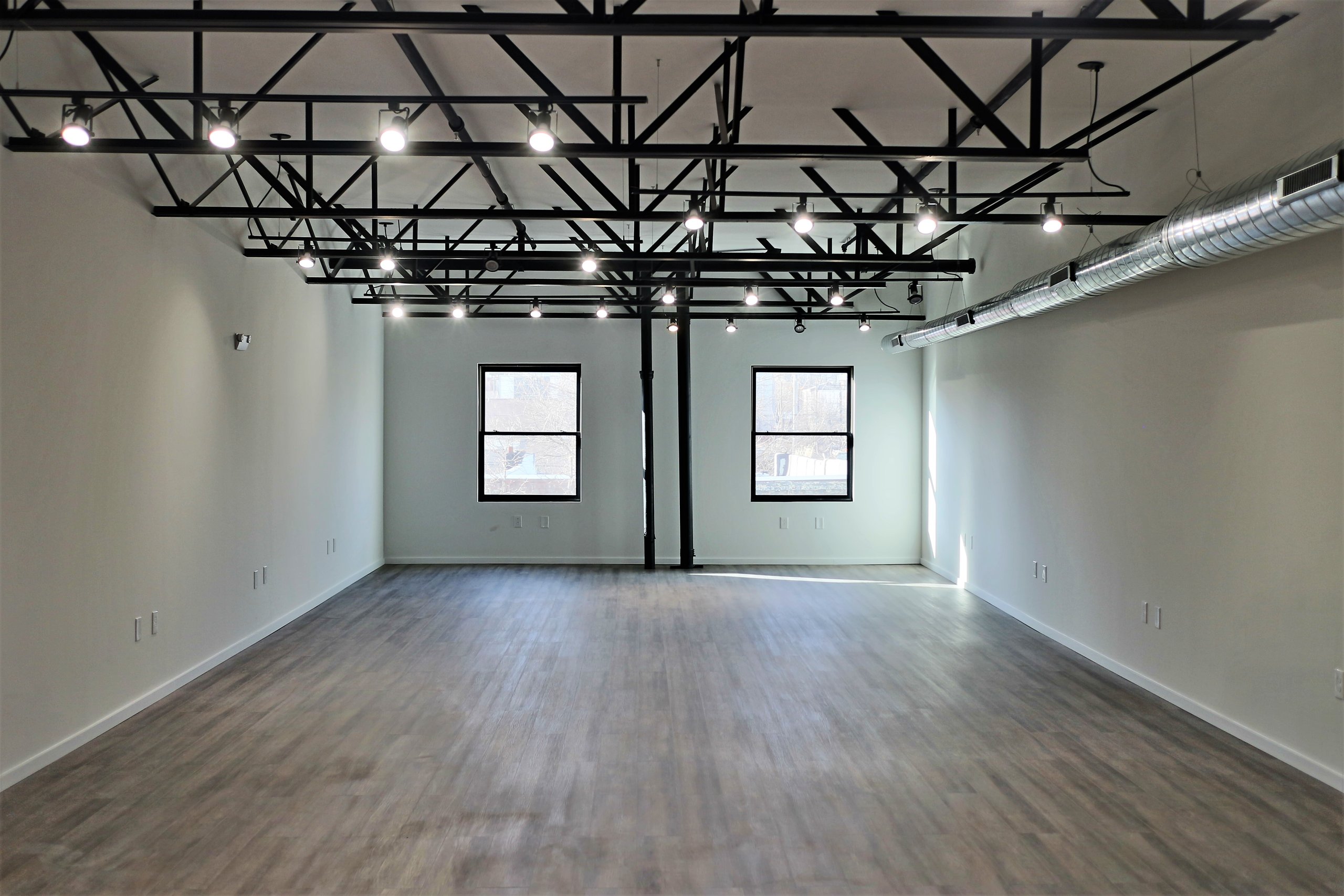 Office space with exposed steel truss and white walls at Billy Penn Studios, Olde Kensington