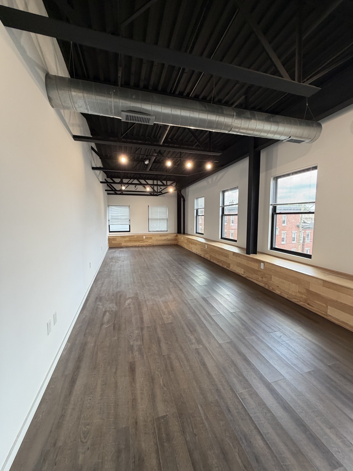 A 400 sq ft office at Billy Penn Studios, with black steel framing and a wood clad wall