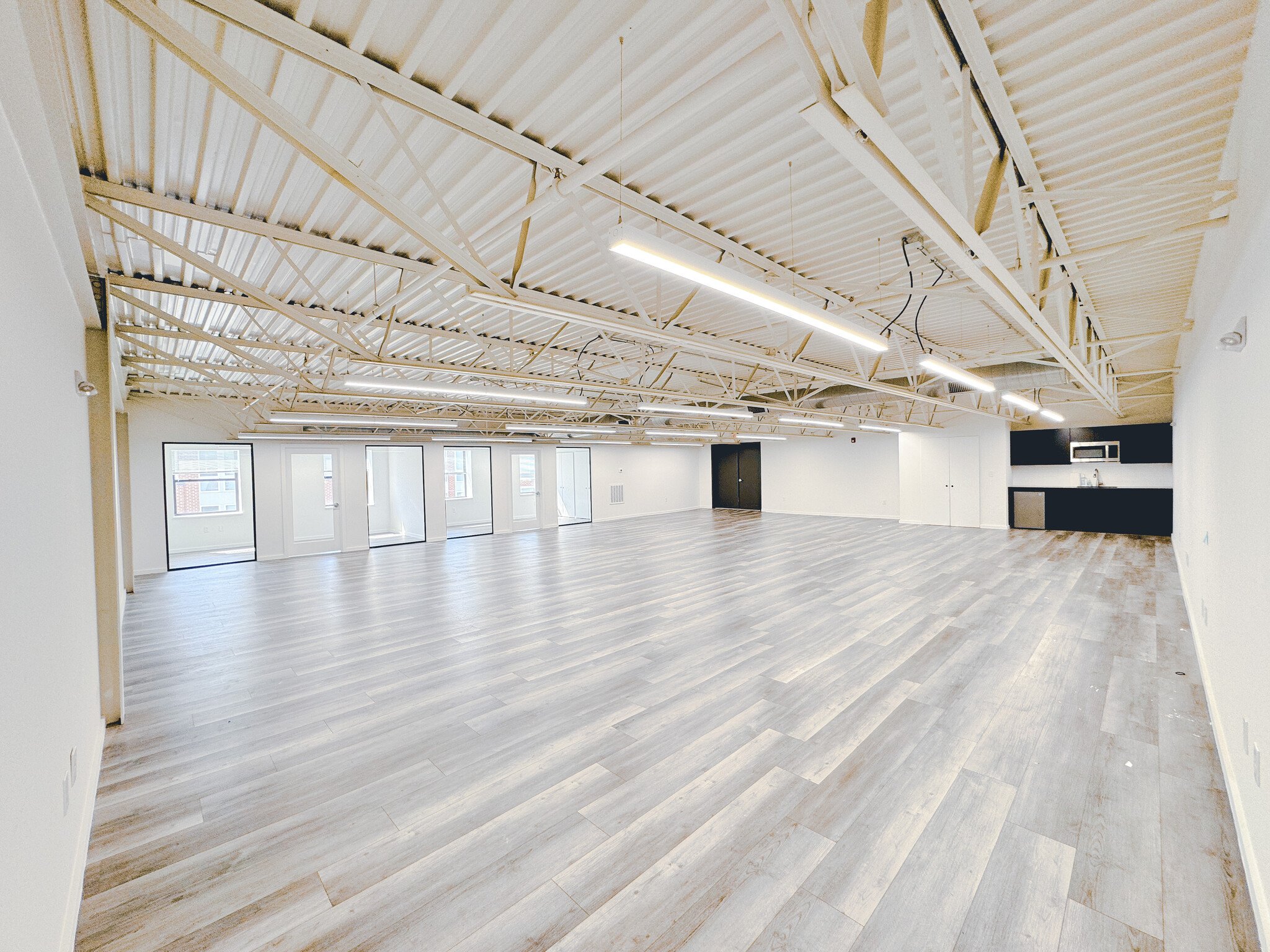 Unit 300 at Billy Penn Studios — a 1,900 sq ft open plan space with a white painted truss ceiling and a kitchenette