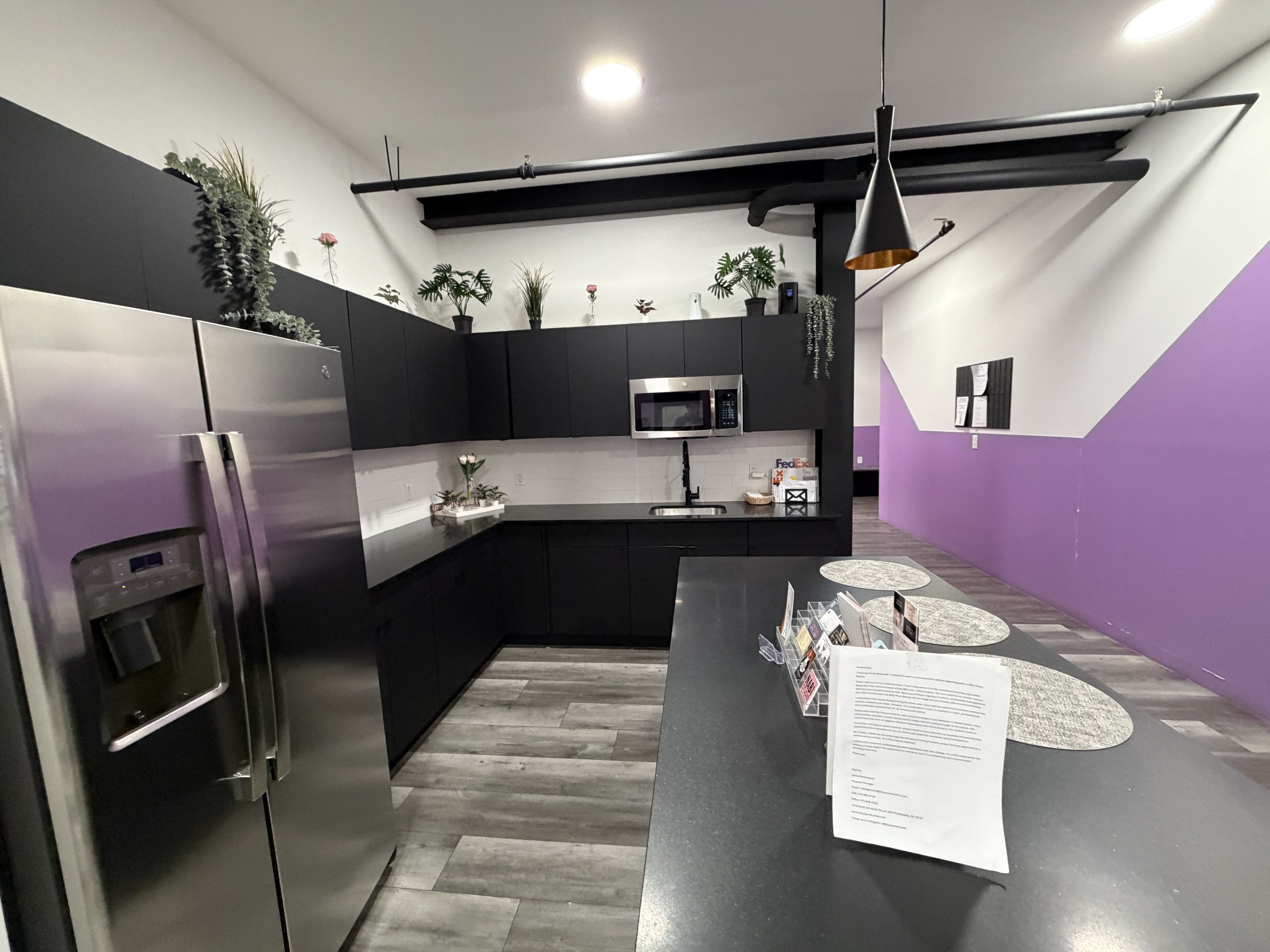 The shared kitchen for the salon suites at Billy Penn Studios, with a fridge, sink and island