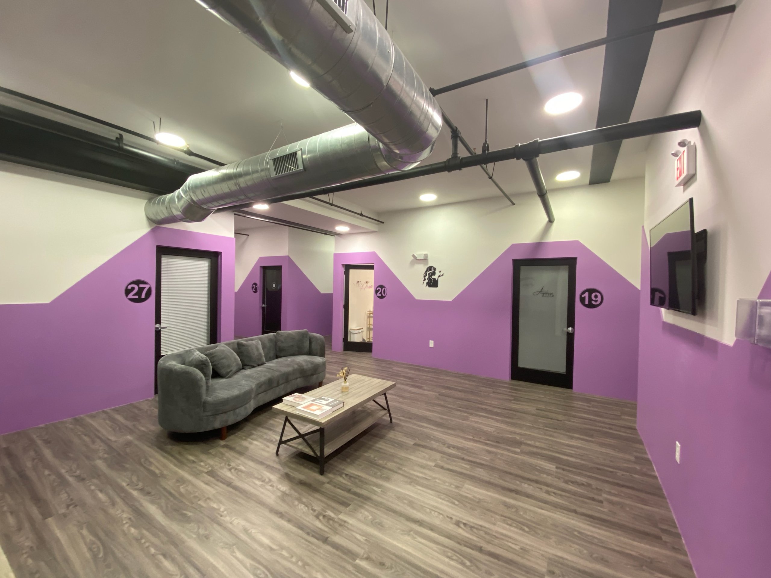 Salon suites at Billy Penn Studios, with numbered private doors off a shared waiting lounge